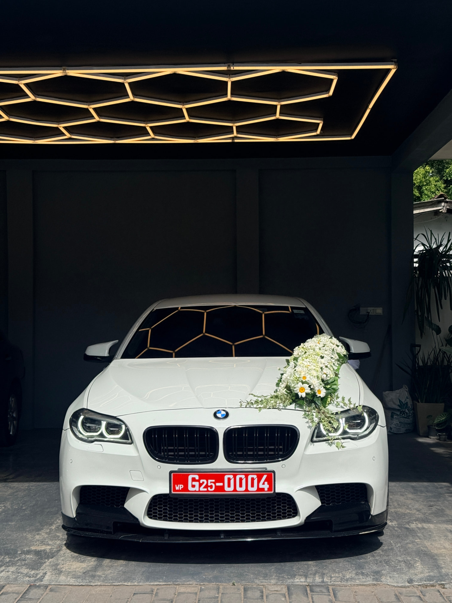 White BMW with hexagon lighting overhead